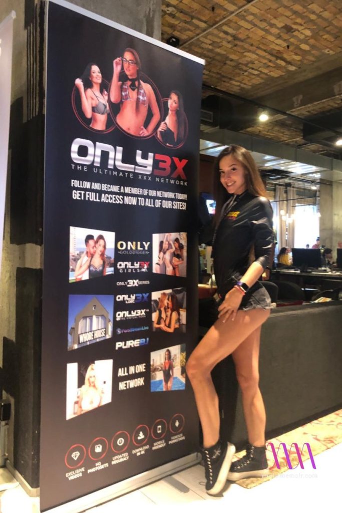 Amirah Adara posing beside Only3X banner in casual outfit