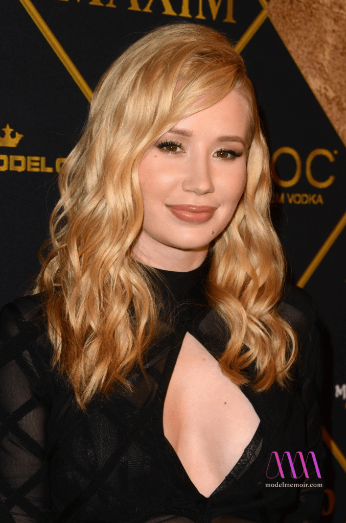 A photo of Iggy Azalea at an awards gala weating a black dress.