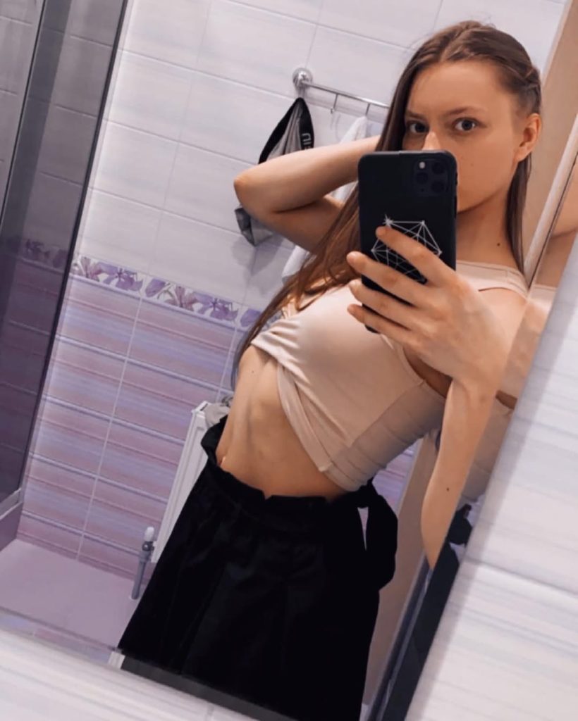 Mia Split taking a stylish mirror selfie in casual attire.